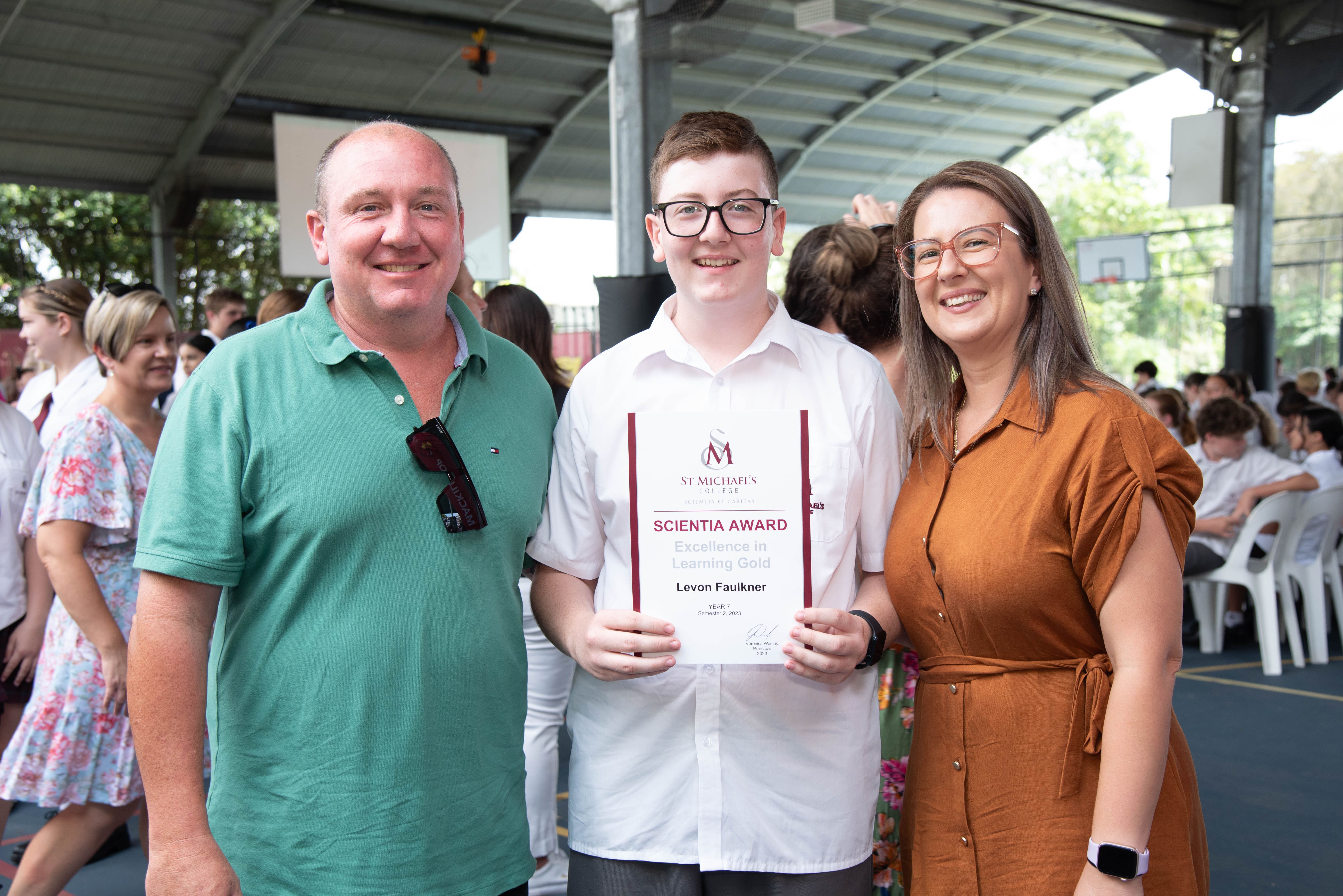Student presenting a certificate with his parents
