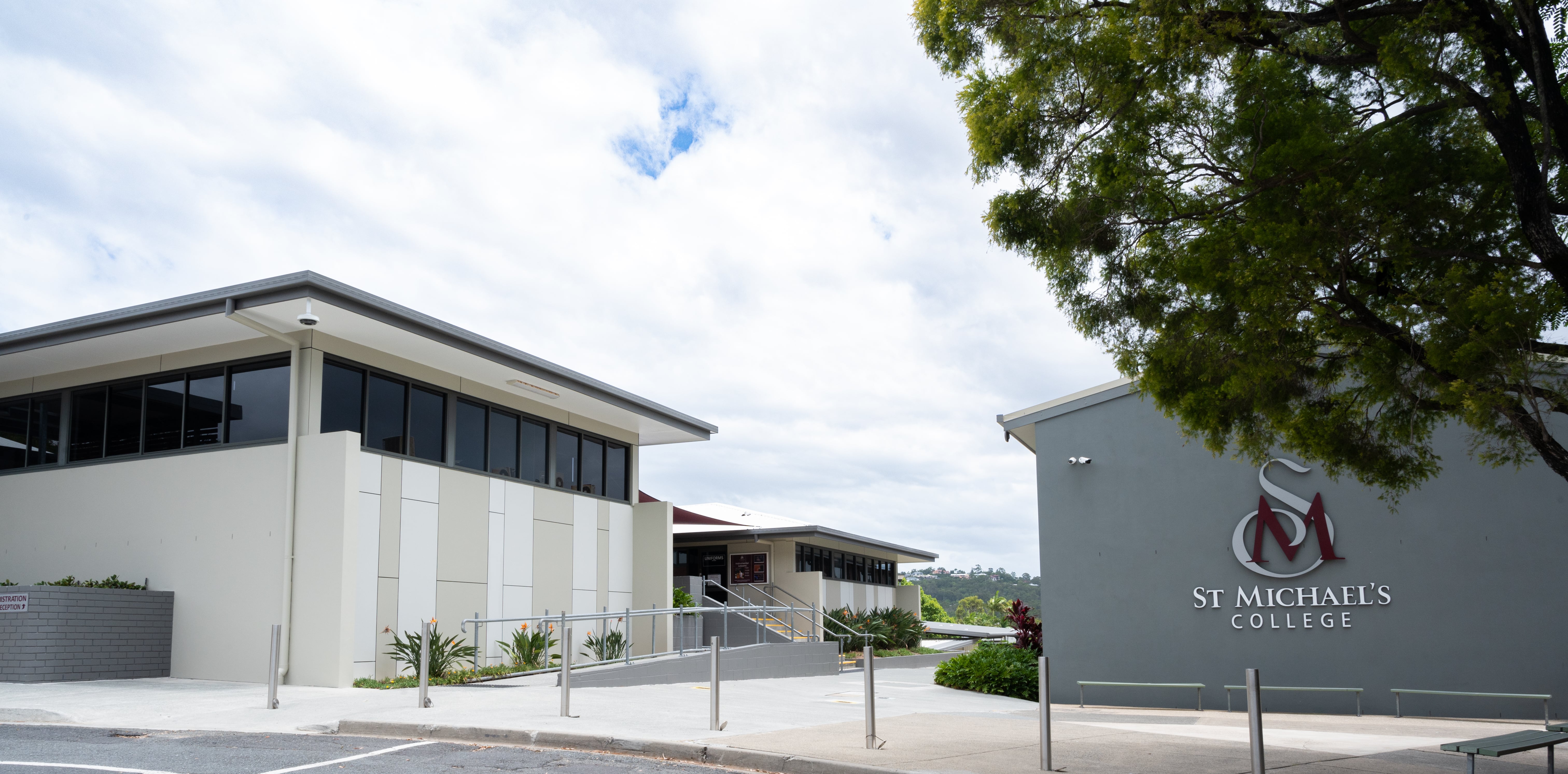 Modern school buildings at St Michael’s College with accessible ramps, landscaped gardens, and campus signage visible in an outdoor setting