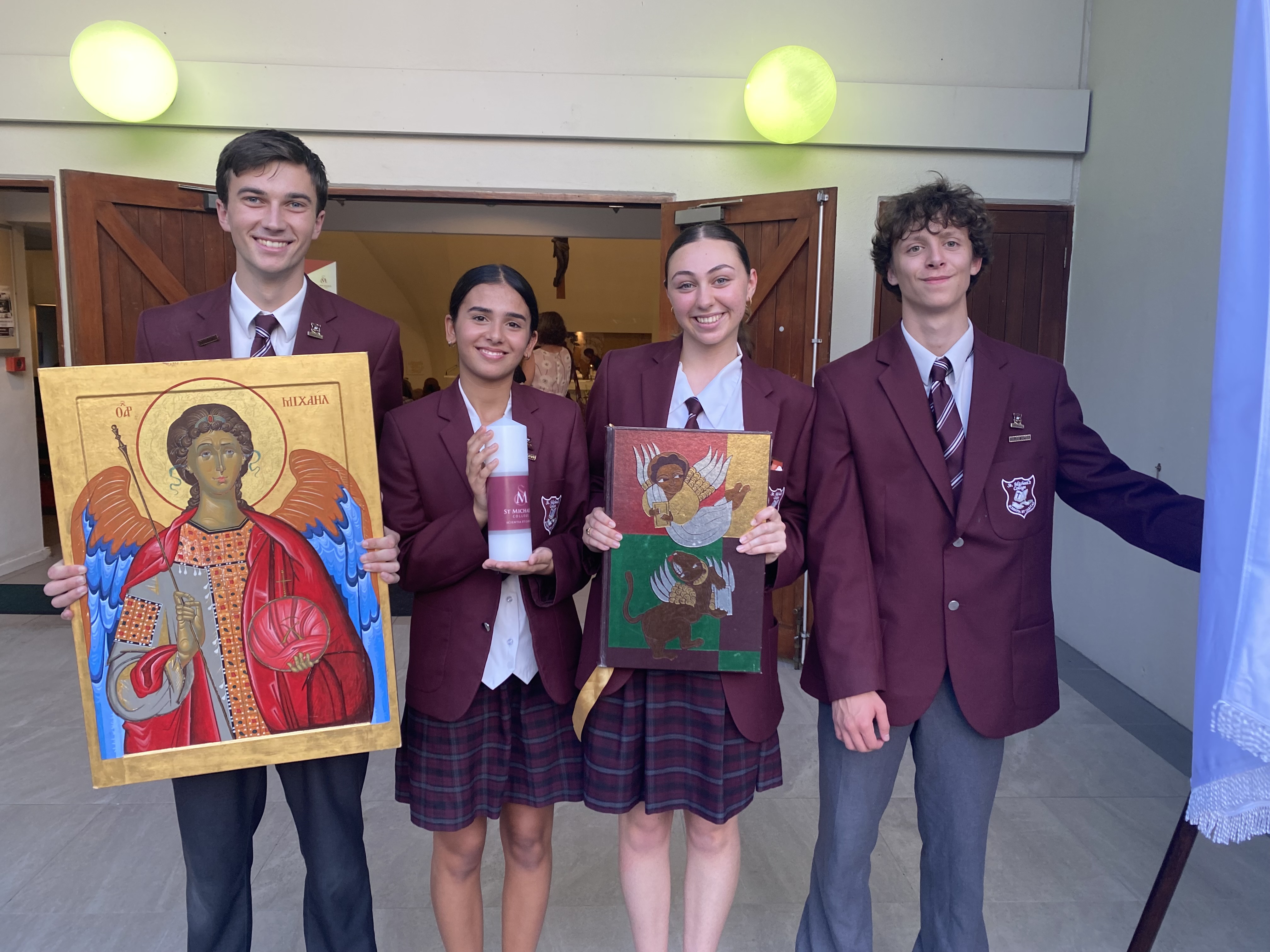 Students holding religious icons during 2024 commencement Mass ceremony at Sacred Heart Church