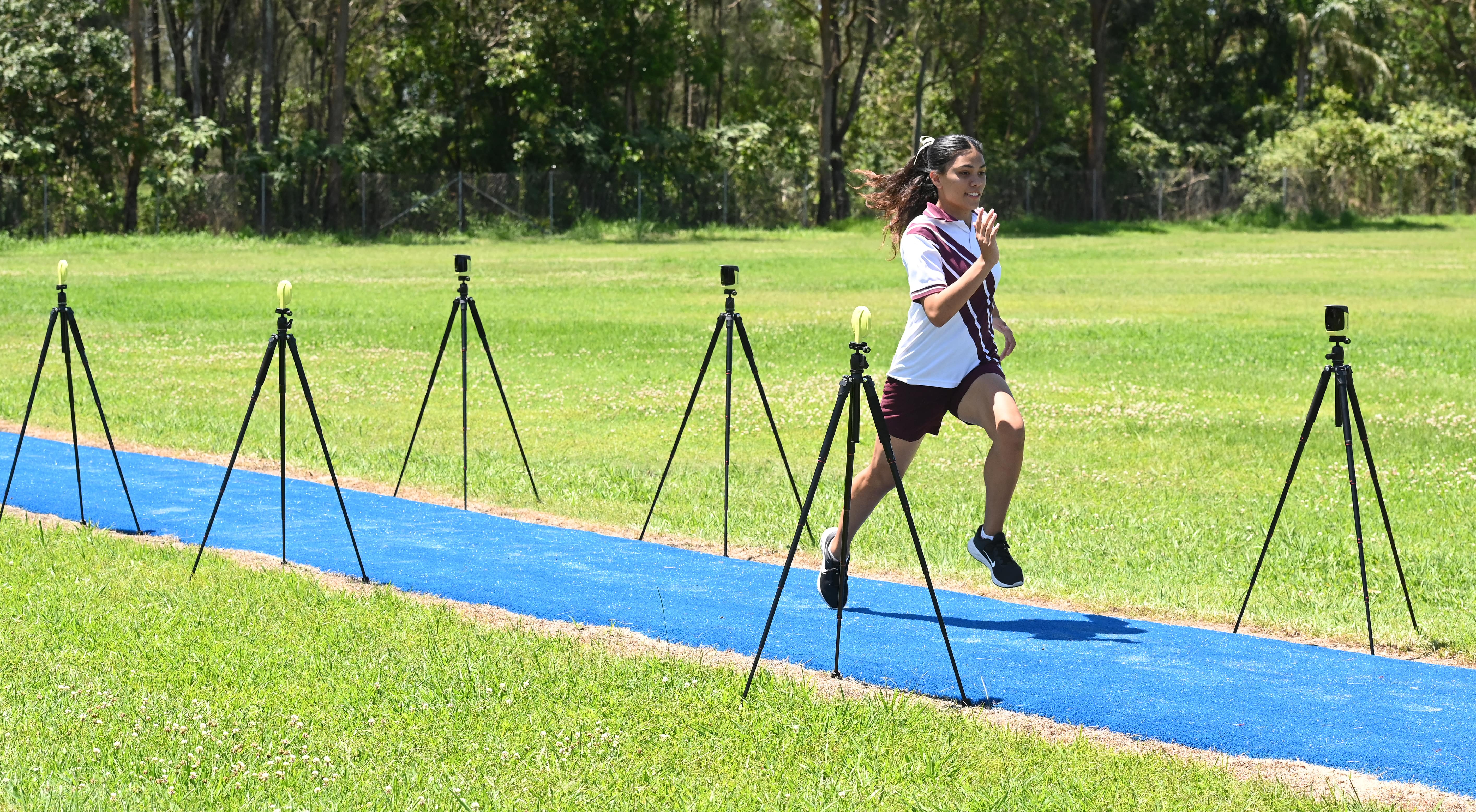 Student sprinting along a track during a fitness testing activity with timing equipment set up