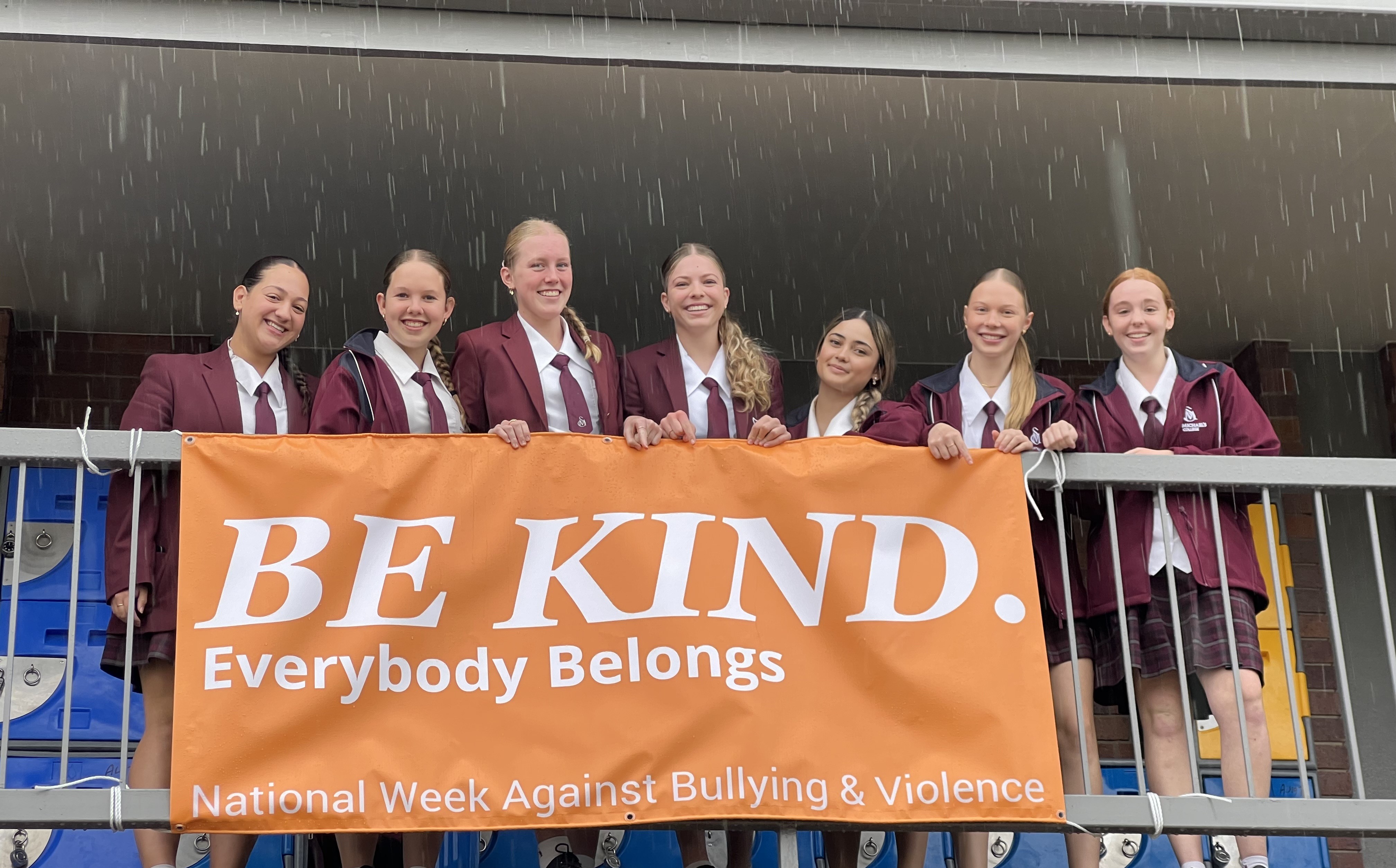 Students holding the banner BE KIND during 2024 NWA AGAINST BULLYING & VIOLENCE
